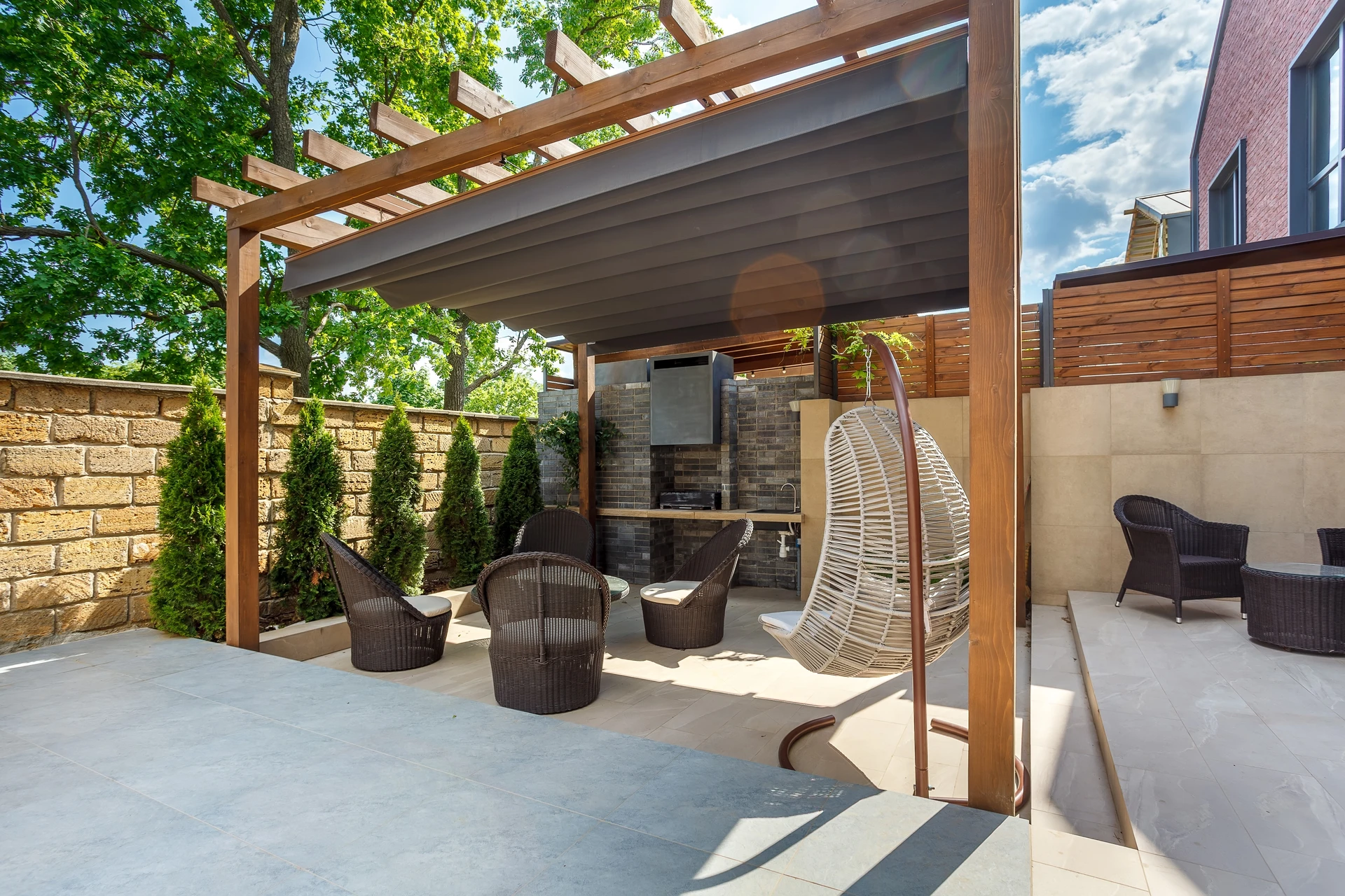 Terrasse en bois surélevée avec parasol déporté, mobilier de jardin et barbecue